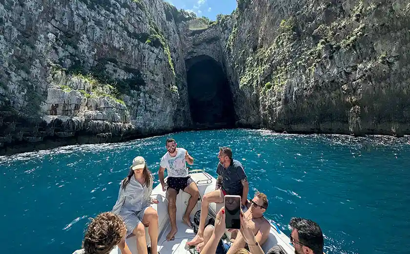 Lancha rápida navegando junto a los acantilados de piedra caliza de la Península de Karaburun en un día de verano, Vlora Albania