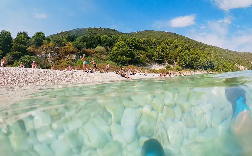 Agua turquesa tranquila en la Cueva de Haxhi Ali en una mañana de primavera sin multitudes, Península de Karaburun