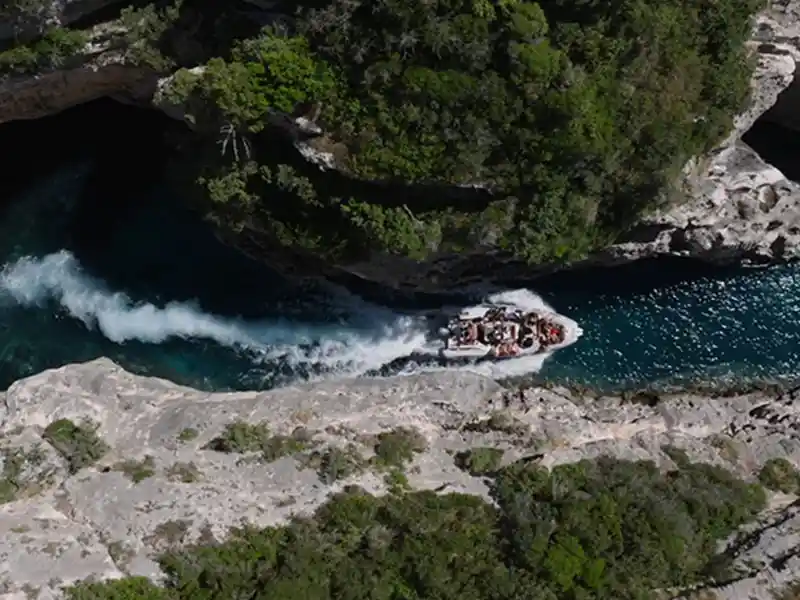 Vista aérea de una lancha rápida navegando por el estrecho Cañón de los Contrabandistas entre acantilados de piedra caliza, Península de Karaburun Albania