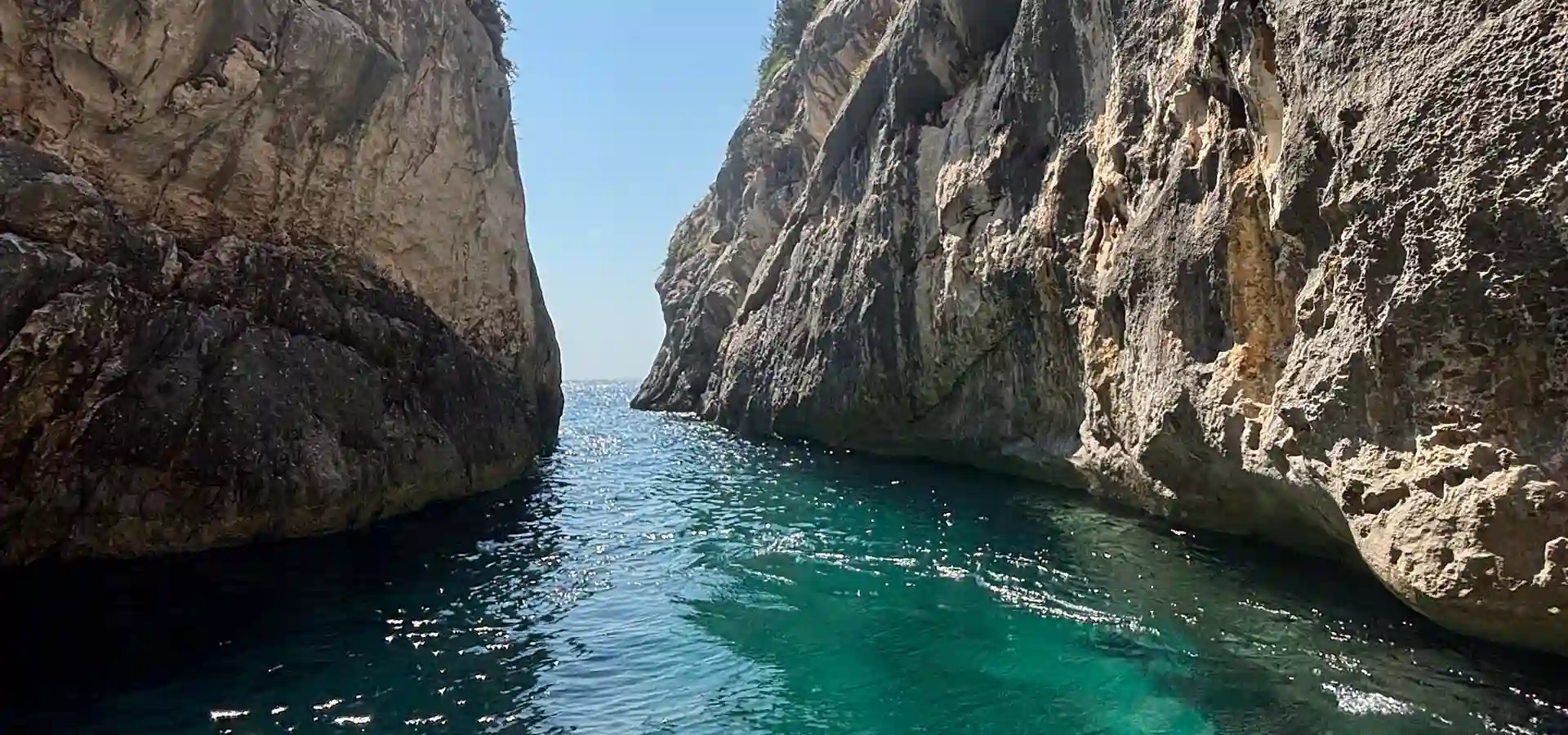 Aerial view of a speedboat navigating through the narrow Canyon of Smugglers, Karaburun Peninsula Albania