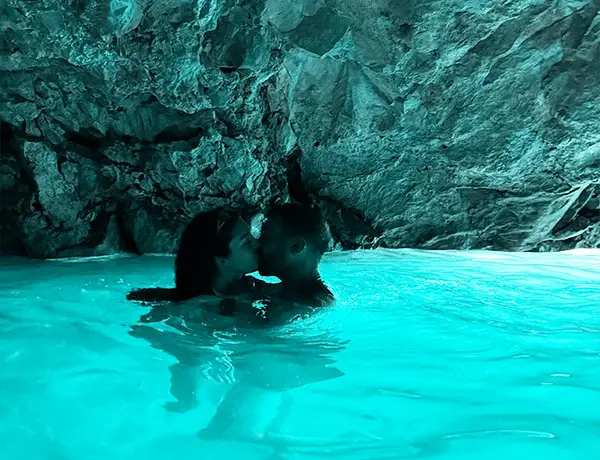 Couple swimming inside Blue Cave with glowing turquoise water in Vlore Albania