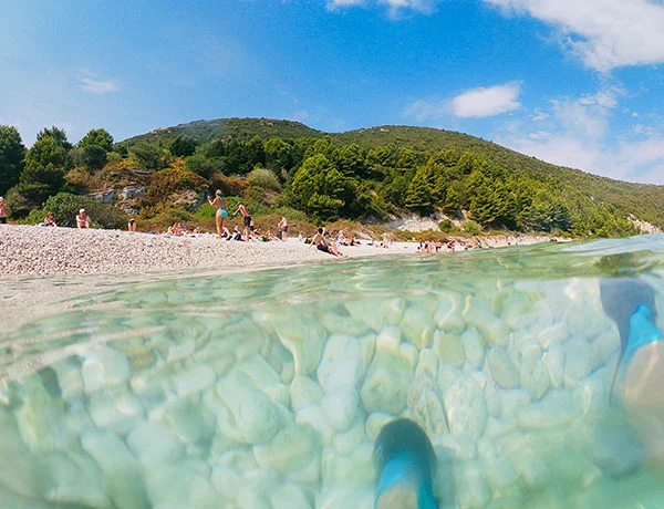 Plage préservée de la péninsule de Karaburun avec eau cristalline et visiteurs profitant du soleil, Albanie