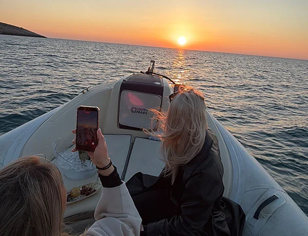 Passagers observant le coucher du soleil depuis un hors-bord lors d'une excursion en soirée depuis Vlora