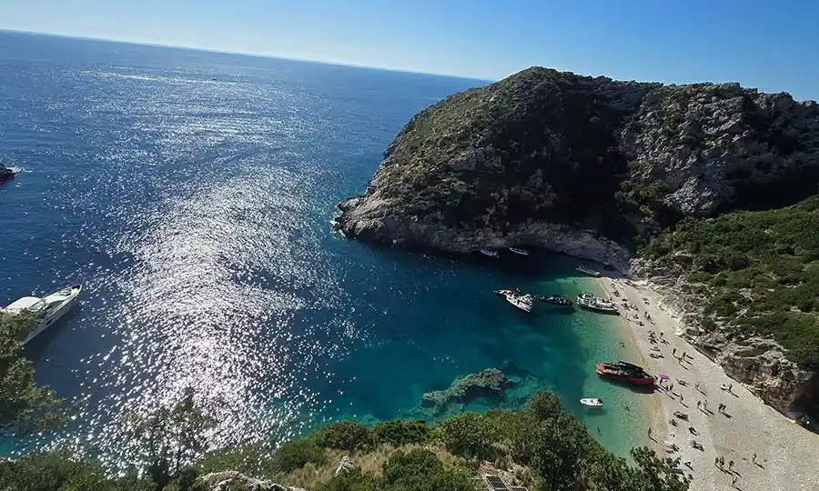 Vista aerea della Baia di Grama con acqua turchese e scogliere calcaree, Penisola di Karaburun Albania